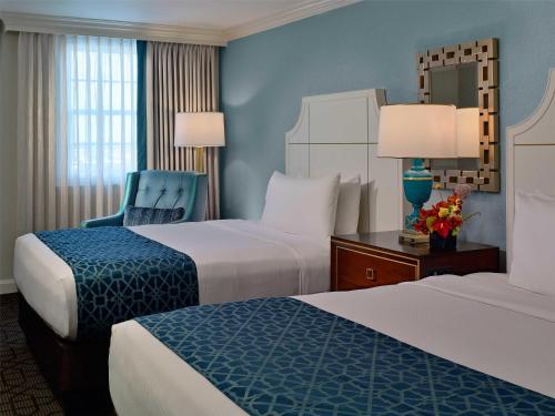 a hotel room with two beds and a chair at The Royal Sonesta New Orleans in New Orleans