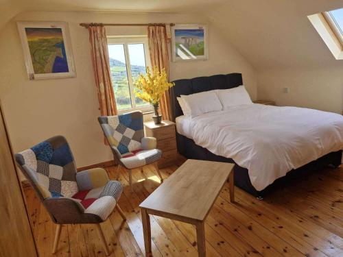a bedroom with a bed and a table and chairs at Villa Daffodil - Sleeps 2 & Stunning Seaside Views in Cahersiveen