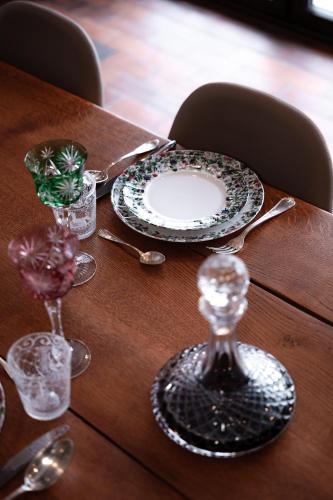 - une table en bois avec une assiette et un verre de vin dans l'établissement Le domaine de rountz, à Rountzenheim