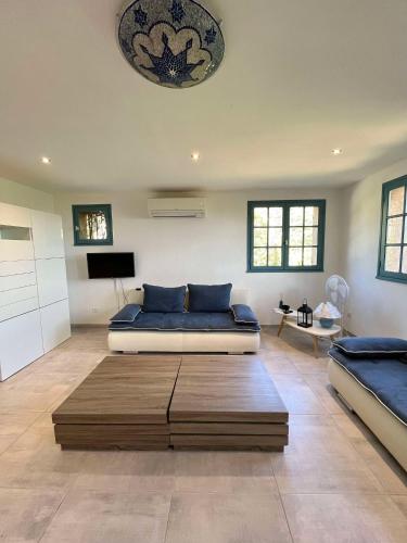 Cette grande chambre comprend deux lits et une table. dans l'établissement Bel appartement proche du centre ville, à Santa-Reparata-di-Balagna