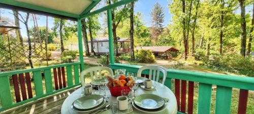 ein Tisch mit einer Obstschale auf einem Balkon in der Unterkunft Camping 3 étoiles - Parc aquatique - ccbbeec in Beaumont-du-Périgord