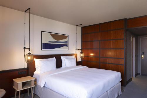 a bedroom with a large white bed with wood paneling at Scandic Nürnberg Central in Nürnberg