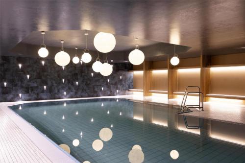 a large swimming pool with lights hanging over it at Scandic Nürnberg Central in Nürnberg