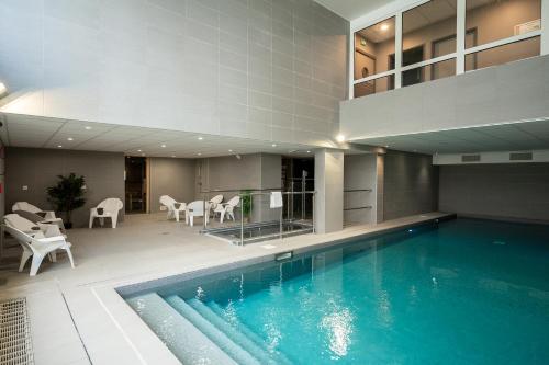 a swimming pool in a building with a house at Nemea Appart Hotel Europe Velizy Villacoublay in Vélizy-Villacoublay