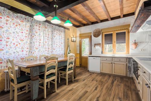 a kitchen with a large wooden table and chairs at Jardín del Mar in Mougás