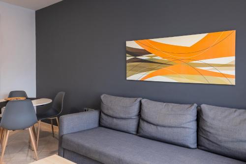 a living room with a couch and a painting on the wall at Hotel Spa Cádiz Plaza in Cádiz