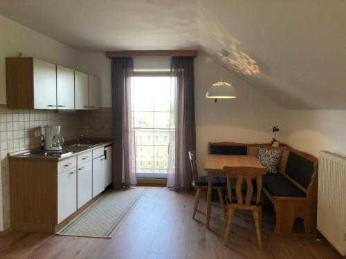a kitchen and dining room with a table and a window at Ferienwohnungen Hackerhof in Bad Füssing