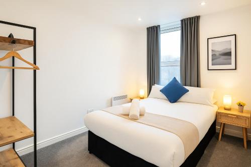 a bedroom with a large bed and a window at 2 Bedroom Apartment Near City Centre, Uni & Parks! in Cardiff