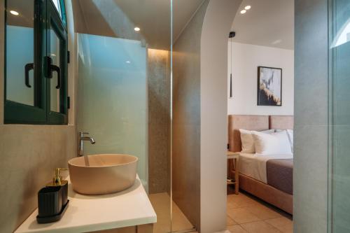 La salle de bains est pourvue d'un lavabo et d'un lit. dans l'établissement Eos Whisper, à Elounda