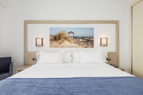 a bedroom with a bed and a picture of a beach at Hotel Spa Cádiz Plaza in Cádiz