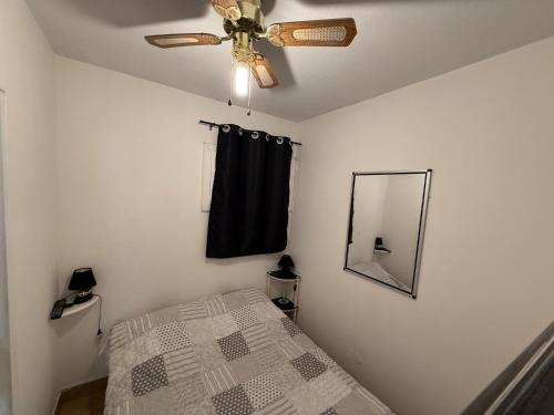 a bedroom with a ceiling fan and a mirror at L'Enclos de la plage in La Ciotat