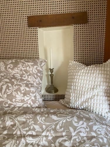 a bedroom with a bed with a pillow and a candle at Maison des Roses in Fontaine-Chaâlis