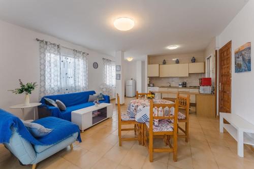 a living room with a blue couch and a table at Spacious apartment with the private terrace in Arona