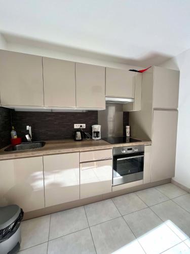 une cuisine avec des armoires blanches et un évier dans l'établissement Bel appartement au calme, à Santa-Reparata-di-Balagna