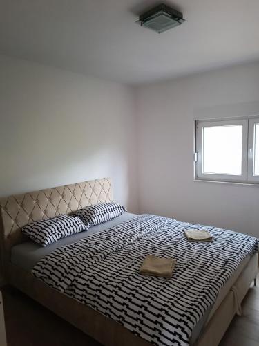 a bed in a white room with a window at Apartment Horizontes Azules in Konjic