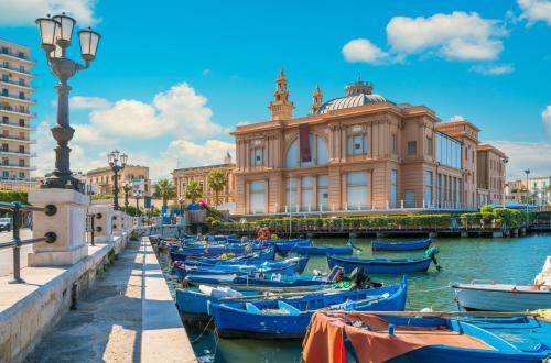 a group of boats in the water in front of a building at 4 Season Cognetti in Bari