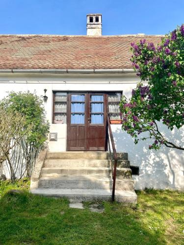 a house with a wooden door and stairs in front at Tulipános Láda Vendégház in Pula