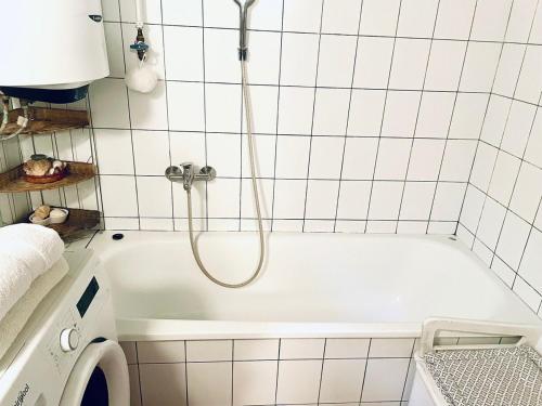 a white bath tub with a shower in a bathroom at Tulipános Láda Vendégház in Pula