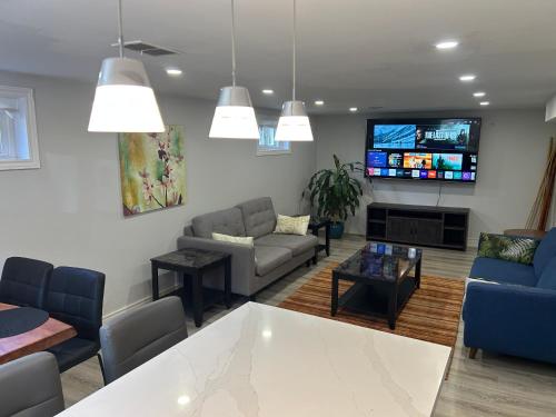 a living room with couches and a tv at Luxury 2 Bedroom House in Richmond Hill