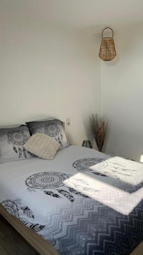 - un lit avec une couette blanche dans une chambre dans l'établissement La Mouette, à Beauvoir