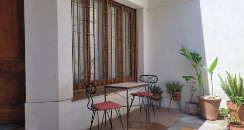 a table and chairs in a room with plants at Departamento para dos personas, zona Basílica de Lujan in Luján