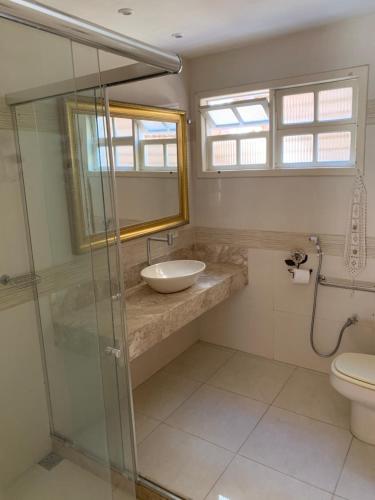 a bathroom with a sink and a glass shower at Toca da Tartaruga 31, PISCINA PRIVATIVA EXCLUSIVA in Armacao dos Buzios