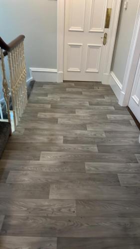 a hallway with a white door and wooden floors at Harbour bridge, Camps bar in Wick