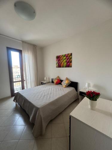 a bedroom with a bed with a painting on the wall at Casa Vacanze Tridente in Trapani