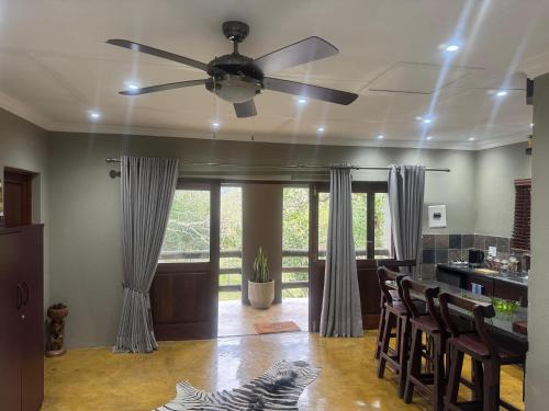 sala de estar con ventilador de techo y mesa en Mountain Dew Quest House, en Noordkaap