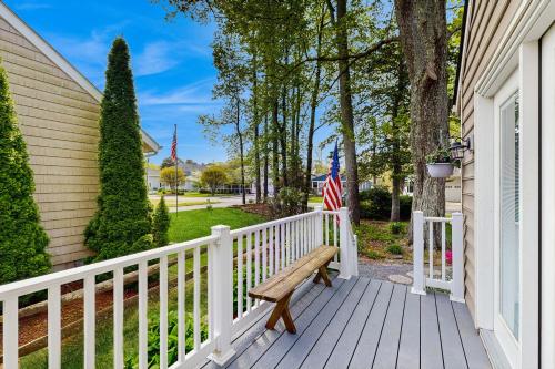 a wooden porch with a bench and an american flag at Town of Bethany Beach --- 417 Lekites Ave in Bethany Beach