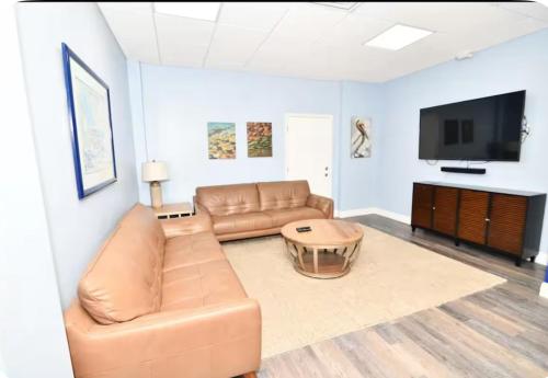 a living room with a couch and a flat screen tv at Vacay Vibes-2 Pools, Pickleball, Coffee Bar, 2 Jacuzzis, Food Truck in Key Largo