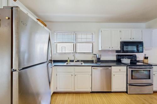 a kitchen with white cabinets and a stainless steel refrigerator at Town of Bethany Beach --- 417 Lekites Ave in Bethany Beach