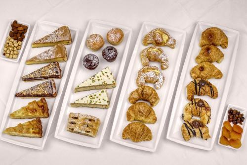 a table with plates of different types of pastries at Hotel Firenze in Venice