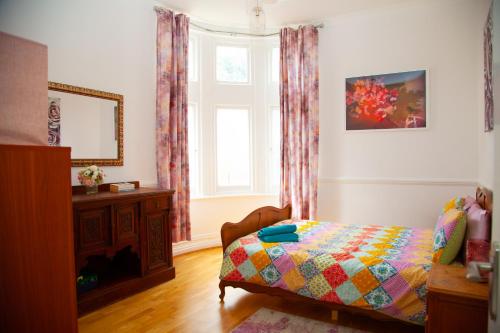 a bedroom with a bed and a window at Bournemouth high street - large 3BR in historical house, 4-5 beds - Groups - Contractors - Families up to 7ppl in Bournemouth