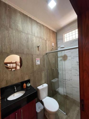 a bathroom with a toilet and a sink and a shower at Hostel Fratelli Costa in Delfinópolis