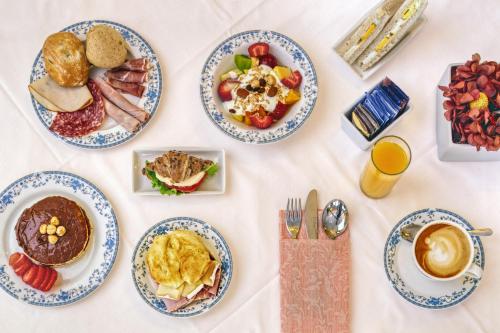 a table with plates of breakfast food on it at Hotel Firenze in Venice