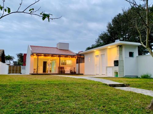 Casa de frente para lagoa com vista deslumbrante e ambiente tranquilo في لاغونا: منزل أمامه حديقة