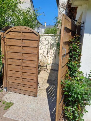 a wooden gate in front of a house at Joli studio au calme dans un jardin privatif in Ouistreham