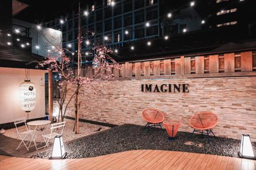 a group of chairs and tables in front of a brick wall at Hotel Imagine Kyoto in Kyoto