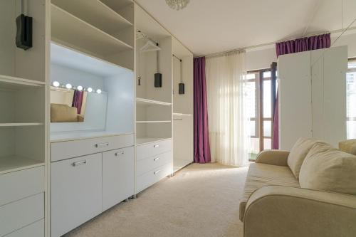 a living room with white cabinets and a couch at Downtown Floreasca Penthouse with Jacuzzi&Sauna in Bucharest