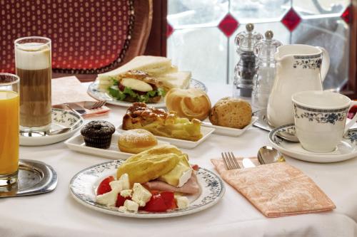 a table with plates of food and cups of coffee at Hotel Firenze in Venice