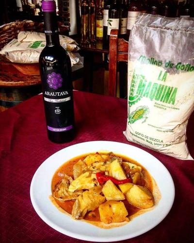 a plate of food on a table with a bottle of wine at Hotel Rural Orotava in La Orotava