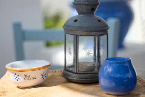 a lantern sitting next to a bowl and a cup at Casa Fiammetta in Leuca