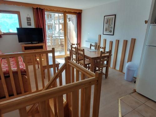 une salle à manger avec une table, des chaises et une télévision dans l'établissement 2 pièces cabine duplex 6 personnes - FR-1-636-14, à Orcières