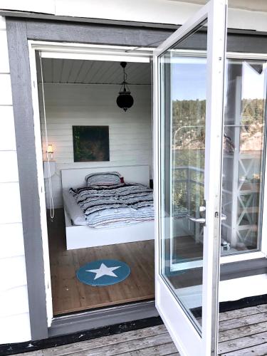a room with a bed inside of a glass door at Seaside Cabin with panoramic view in Bømlo