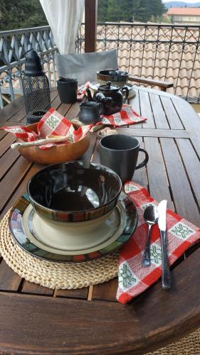 a wooden table with a plate of food on it at The house on the road of Love in Vytina