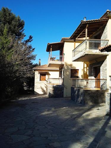 a house with a balcony on the side of it at The house on the road of Love in Vytina