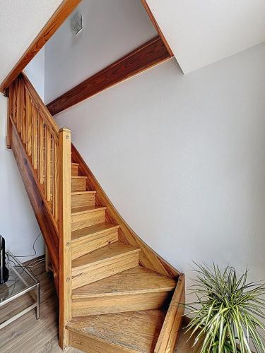 a wooden staircase in a room with a plant at Vue Imprenable Jaude Duplex Tout Confort - Clim in Clermont-Ferrand
