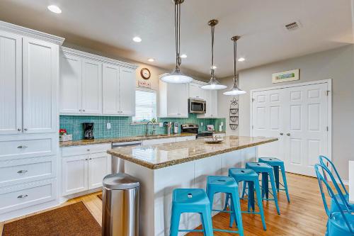 Crystal BeachにあるA Tequila Sunrise by Bolivar Escapesのキッチン(白いキャビネット、青いスツール付)