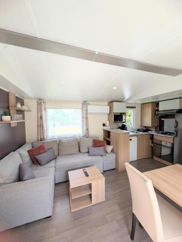 un salon avec un canapé et une table dans l'établissement gite la campagne doré, à Tour-en-Bessin